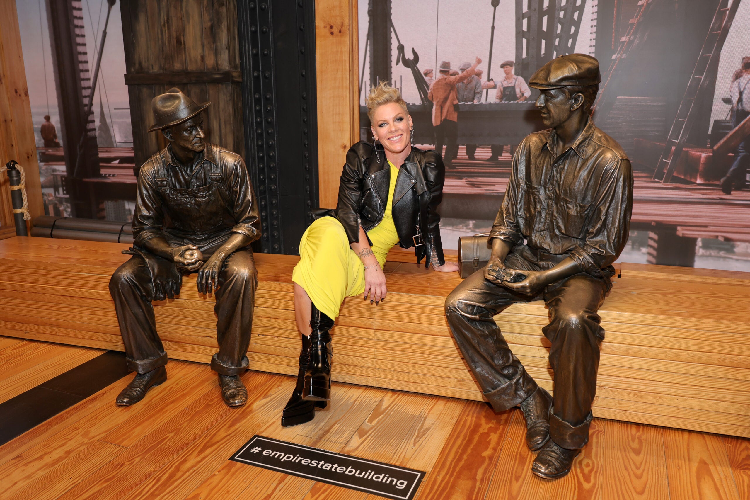 Singer Pink sitting between two bronze statues at ESB
